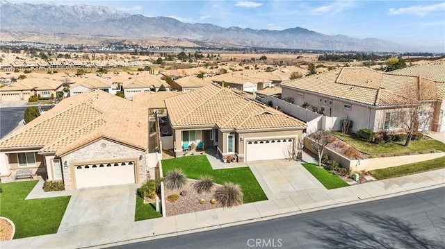 view of front facade with a garage, a mountain view, and a front yard