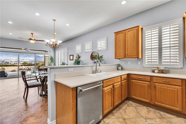 kitchen featuring sink, hanging light fixtures, dishwasher, kitchen peninsula, and ceiling fan with notable chandelier