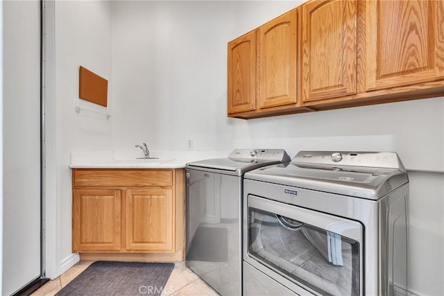 washroom featuring independent washer and dryer, cabinets, light tile patterned flooring, and sink