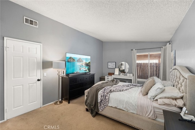 bedroom featuring light colored carpet and a textured ceiling