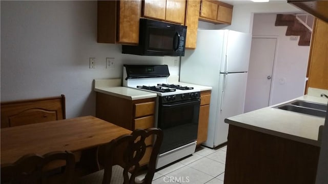 kitchen with range with gas cooktop, sink, white refrigerator, and light tile patterned flooring