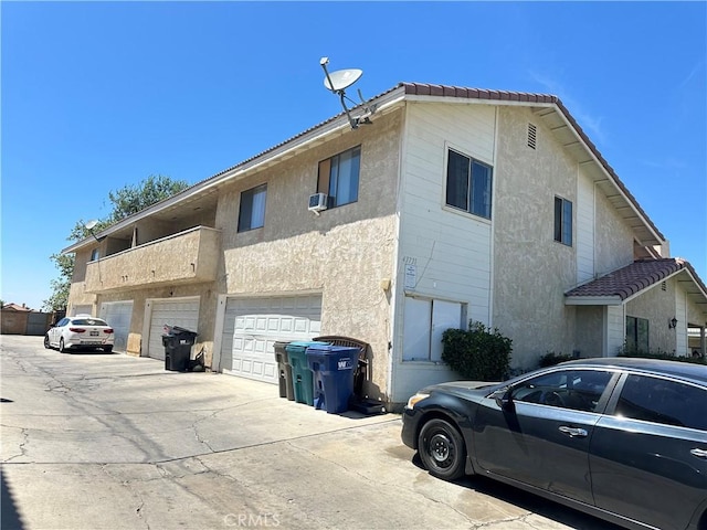 view of side of home featuring a garage and a balcony