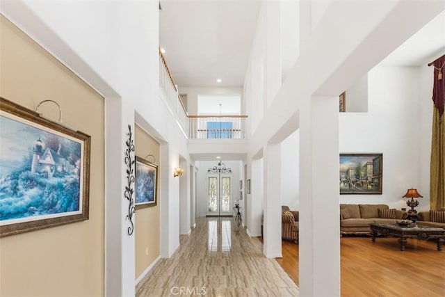 hall featuring a towering ceiling and french doors