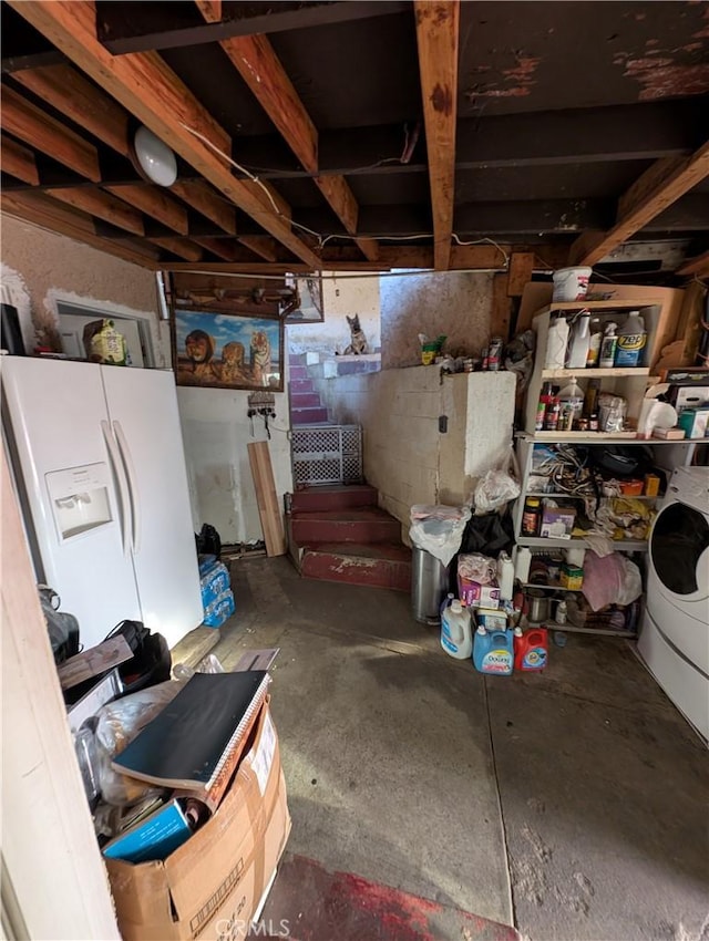 basement with washer / clothes dryer and white refrigerator with ice dispenser