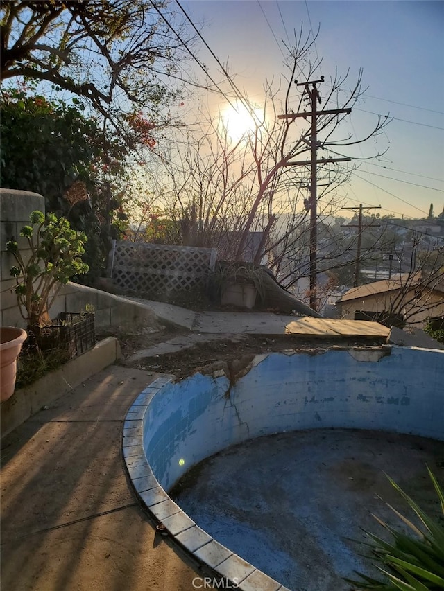 pool at dusk with a patio