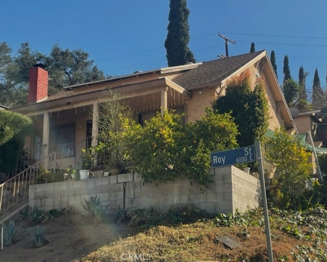 view of side of home featuring stairway and a chimney