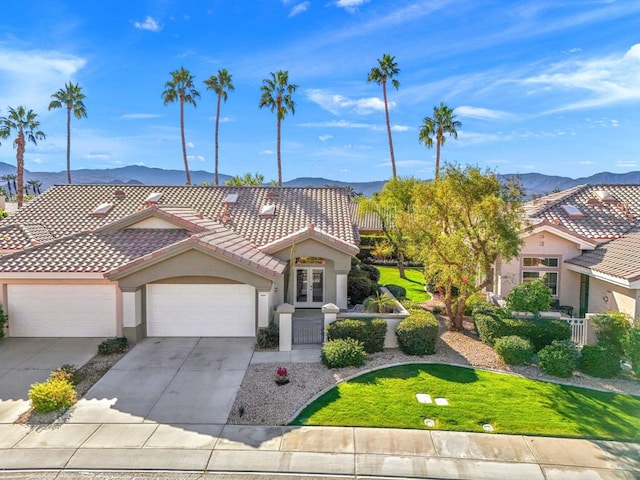 mediterranean / spanish home with a garage, a mountain view, and french doors