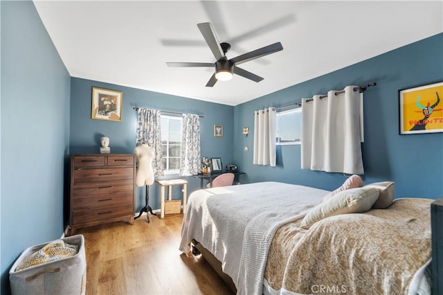 bedroom with ceiling fan and light hardwood / wood-style flooring