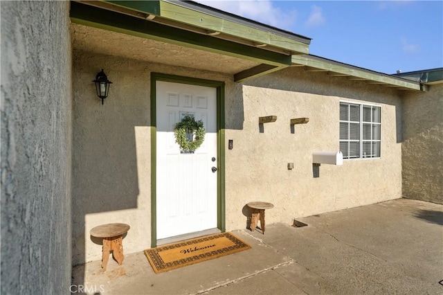 view of exterior entry with a patio