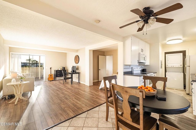 dining room featuring ceiling fan, light hardwood / wood-style floors, and stacked washing maching and dryer