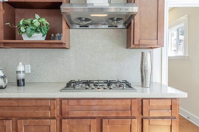 kitchen with stainless steel gas cooktop, exhaust hood, and backsplash