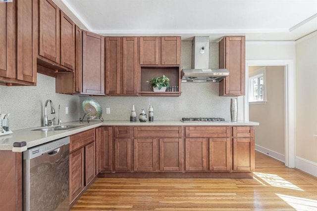 kitchen with light hardwood / wood-style floors, stainless steel appliances, sink, wall chimney range hood, and backsplash