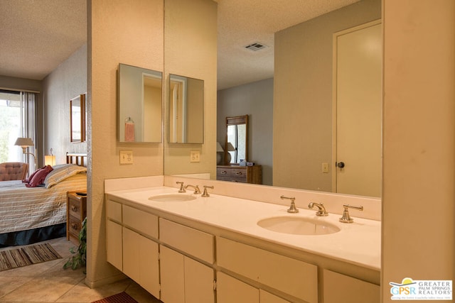 bathroom with tile patterned flooring, vanity, and a textured ceiling