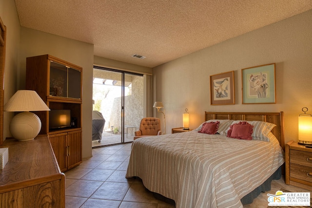 bedroom featuring light tile patterned floors, a textured ceiling, and access to outside