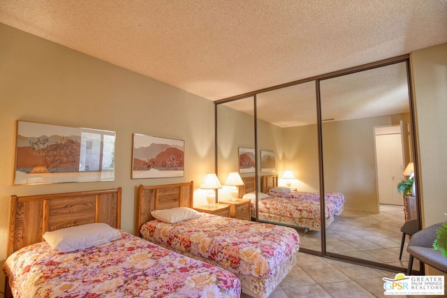 tiled bedroom featuring a textured ceiling and a closet