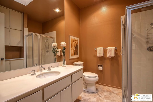 bathroom with tile patterned flooring, vanity, a shower with shower door, and toilet