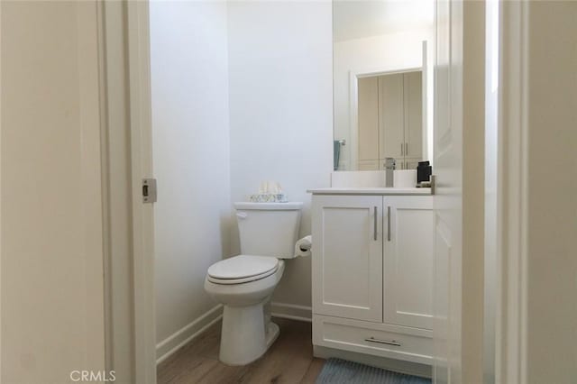 bathroom featuring wood-type flooring, vanity, and toilet