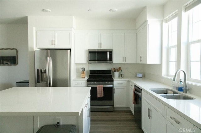 kitchen featuring dark hardwood / wood-style flooring, white cabinetry, sink, and appliances with stainless steel finishes