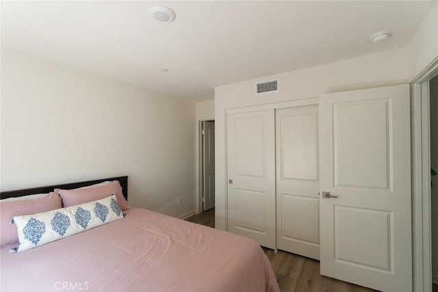 bedroom with hardwood / wood-style floors and a closet