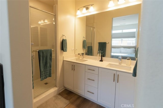 bathroom with hardwood / wood-style floors, vanity, and walk in shower