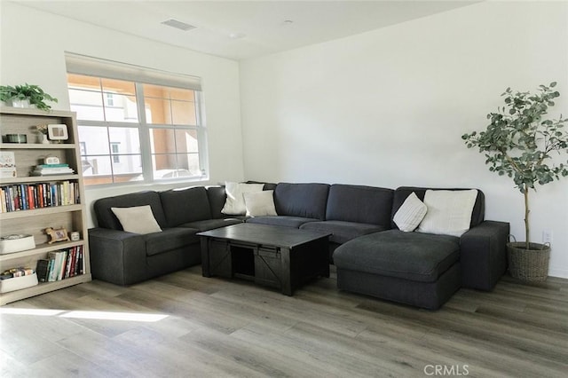 living room with light wood-style floors and visible vents