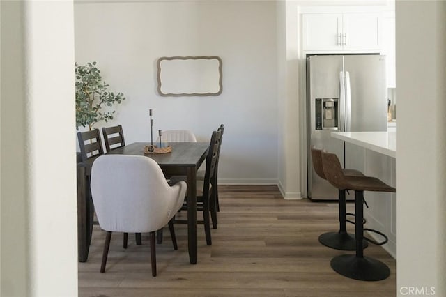 dining room featuring light wood-style flooring and baseboards