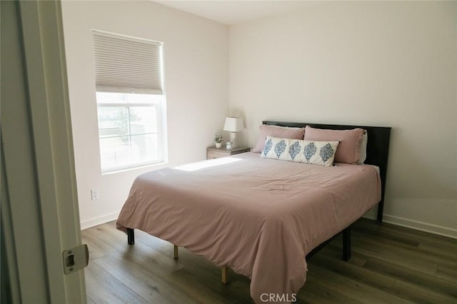 bedroom featuring wood finished floors and baseboards
