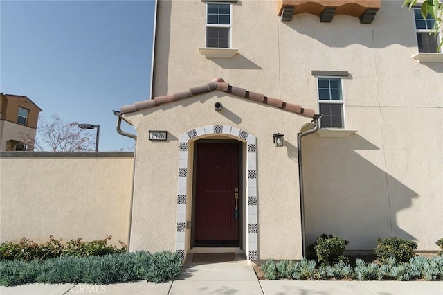 doorway to property featuring stucco siding