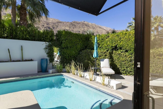 view of pool with a mountain view and a patio