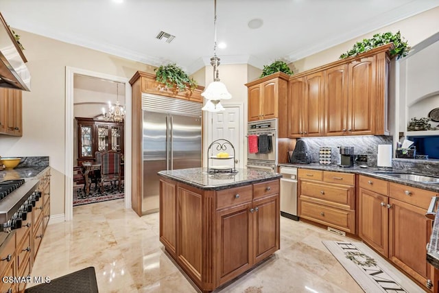 kitchen featuring an inviting chandelier, appliances with stainless steel finishes, tasteful backsplash, hanging light fixtures, and a kitchen island