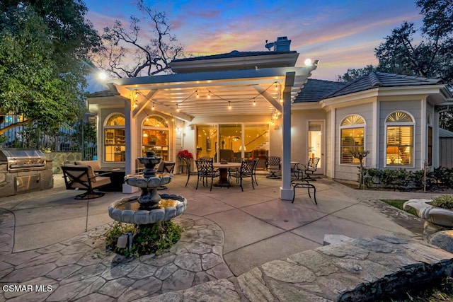 back house at dusk featuring a patio area and area for grilling