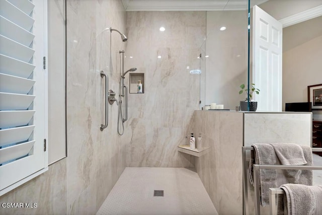 bathroom featuring ornamental molding and tiled shower