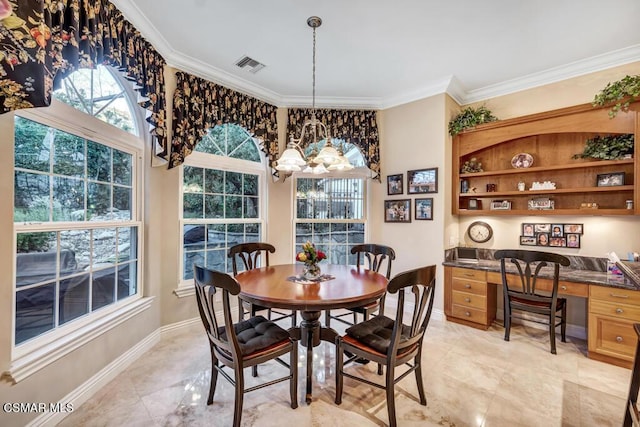 dining room with a chandelier, crown molding, and built in desk