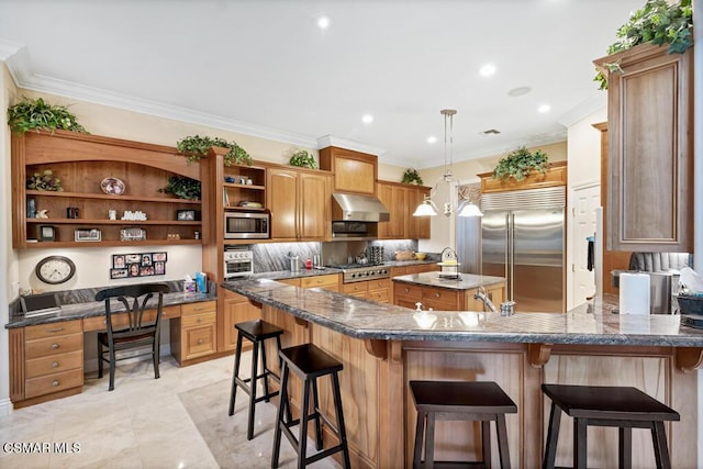 kitchen with a breakfast bar area, appliances with stainless steel finishes, ornamental molding, and dark stone counters