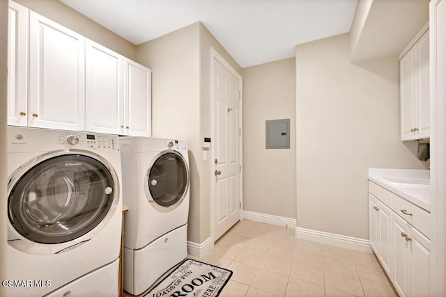 laundry room featuring electric panel, cabinets, washer and clothes dryer, and light tile patterned flooring