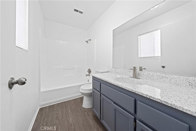 full bathroom featuring hardwood / wood-style flooring, toilet, vanity, and shower / washtub combination