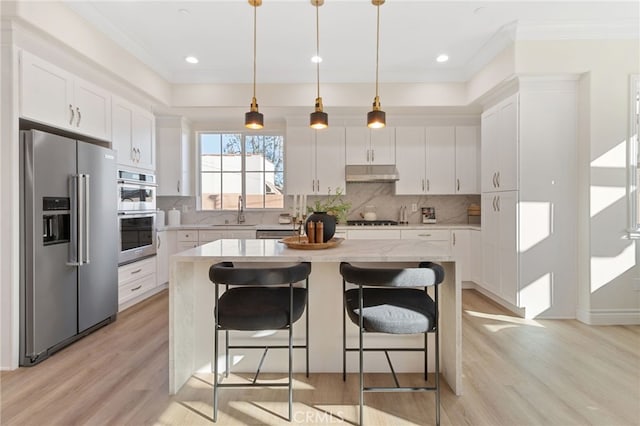 kitchen with stainless steel appliances, a center island, and white cabinetry