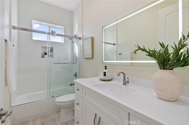 full bathroom with vanity, combined bath / shower with glass door, and toilet