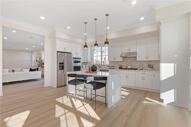 kitchen featuring stainless steel appliances, a center island, a breakfast bar area, and white cabinetry