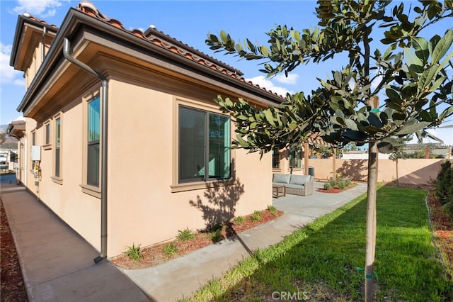 view of home's exterior with a patio and a lawn