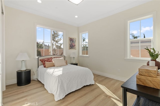 bedroom featuring ornamental molding and light hardwood / wood-style floors