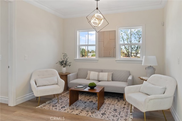 sitting room featuring crown molding, light hardwood / wood-style flooring, and a chandelier