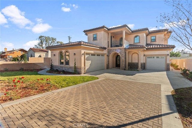 mediterranean / spanish home featuring a balcony, a front lawn, and a garage