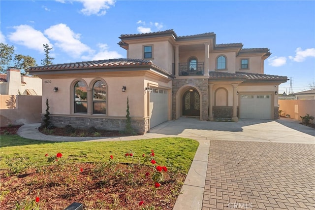 mediterranean / spanish-style house featuring a front yard and a garage