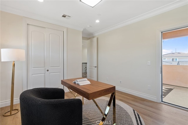 home office with light wood-type flooring and crown molding