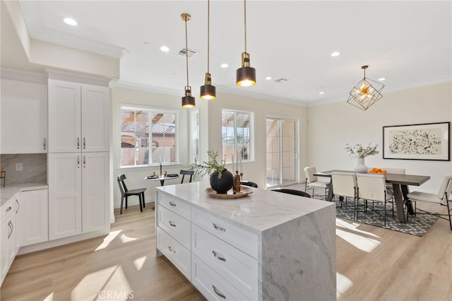 kitchen featuring a kitchen island, pendant lighting, and white cabinetry