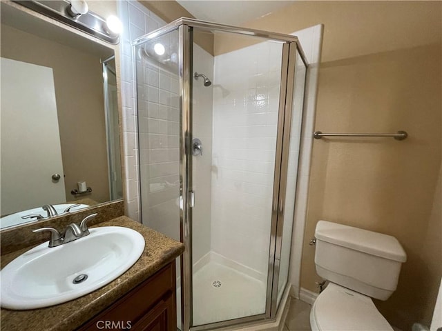 bathroom with toilet, a shower with shower door, and vanity