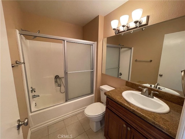 full bathroom featuring shower / bath combination with glass door, vanity, toilet, and tile patterned flooring