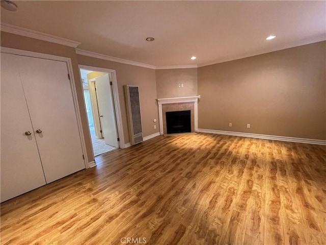 unfurnished living room with ornamental molding and light wood-type flooring