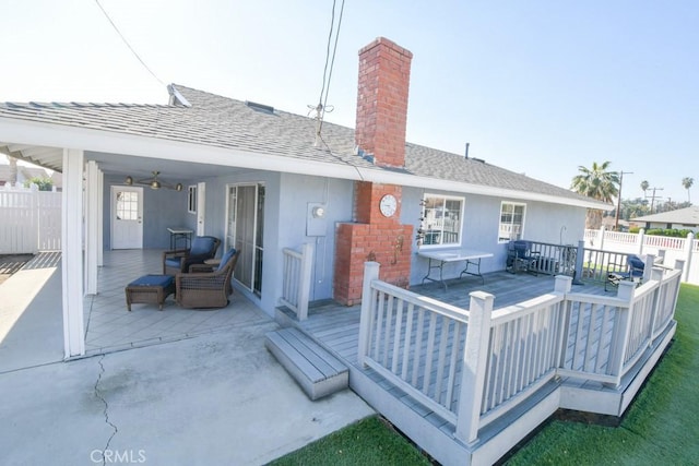 back of property with ceiling fan and a deck